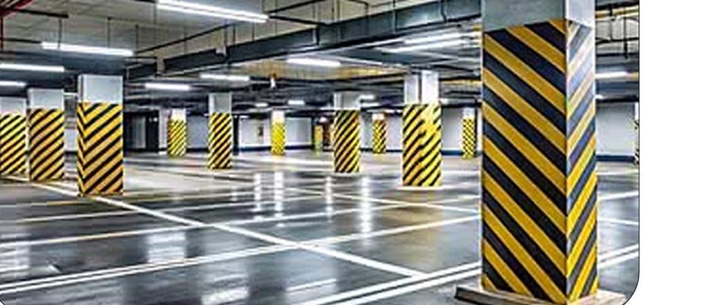 Vagas de garagem sinalizadas em pilares amarelos e pretos